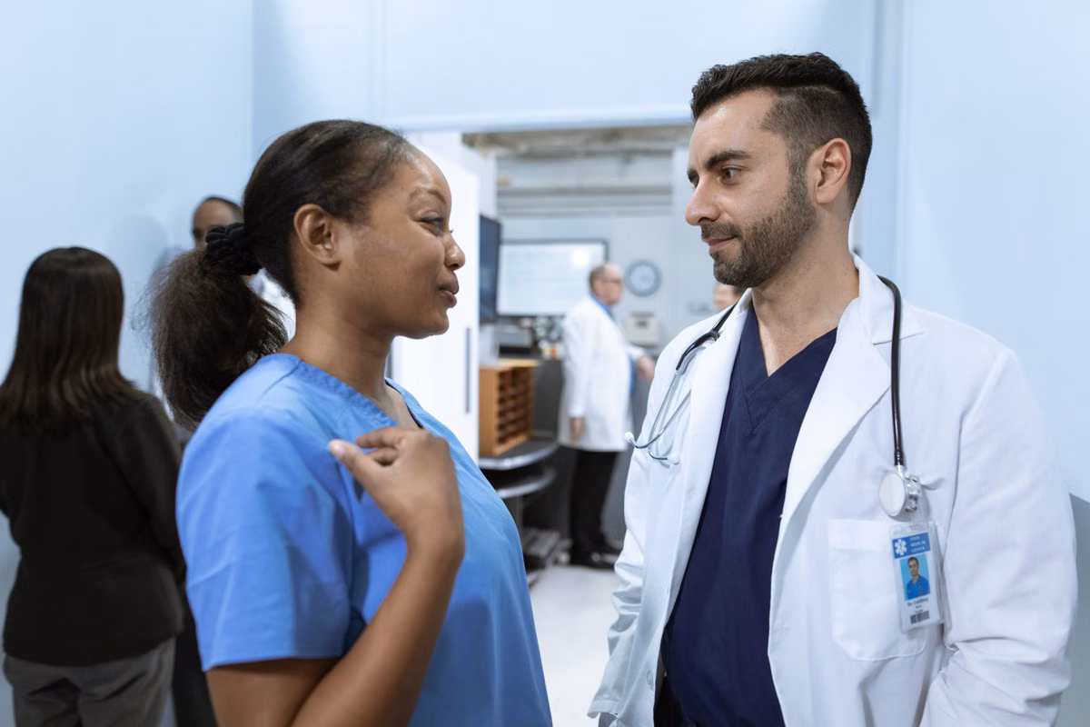 Healthcare professionals discussing patient care coordination in a hallway